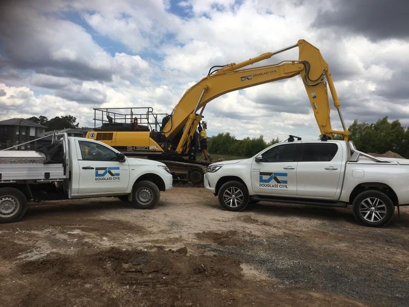 Douglass Civil branded utes parked in front of a Douglass Civil excavator on a Western Sydney site