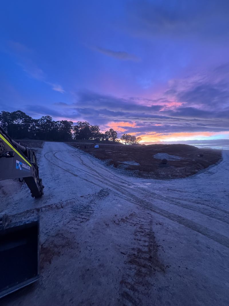 Douglass Civil excavator boom on a site road at dawn