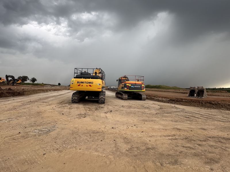 Two Douglass Civil excavators parked up on site as a storm rolls in